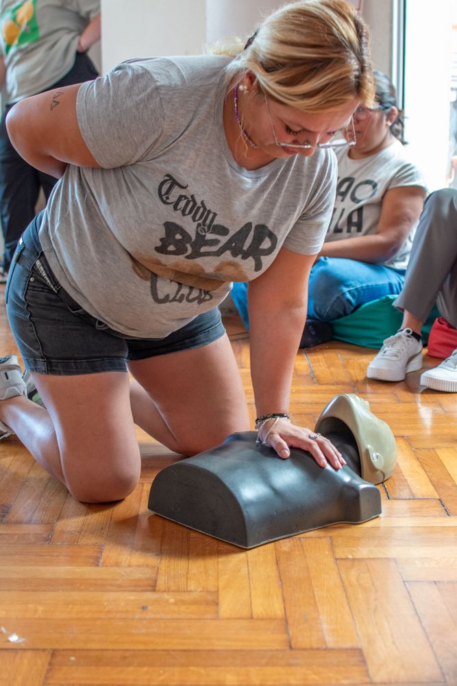 Participant practising chest compressions on a CPR manikin during a first aid training session